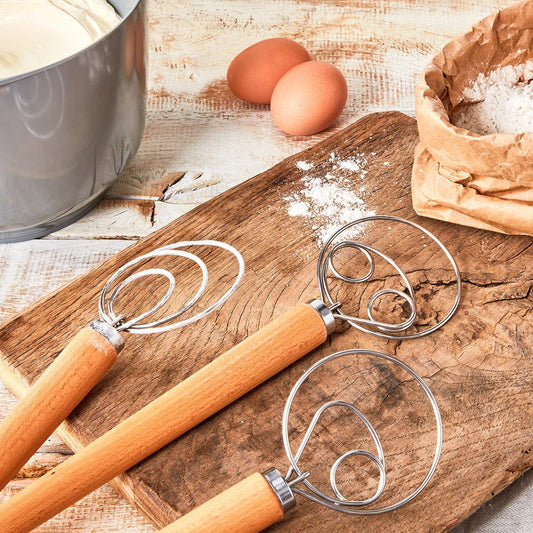 Wooden cutting board with dough scrapper, flour, eggs, and a pot on a rustic wooden surface.