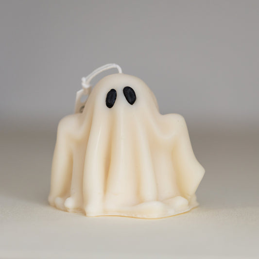 A beige sculptural candle designed to resemble a ghost, with a hanging loop on top.