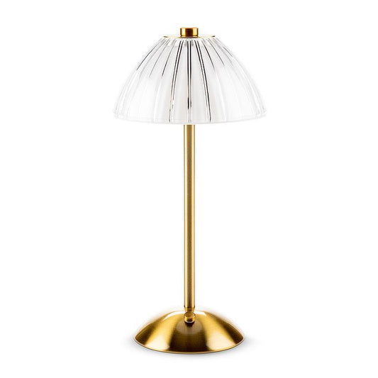 Table lamp with gold base and clear glass shade on a white background