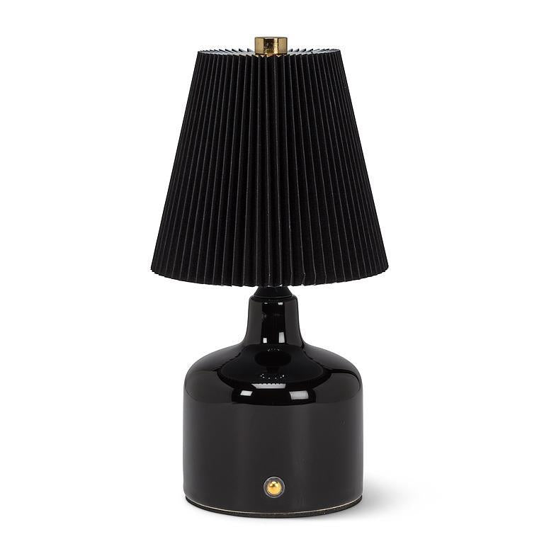 Black table lamp with pleated shade on a white background