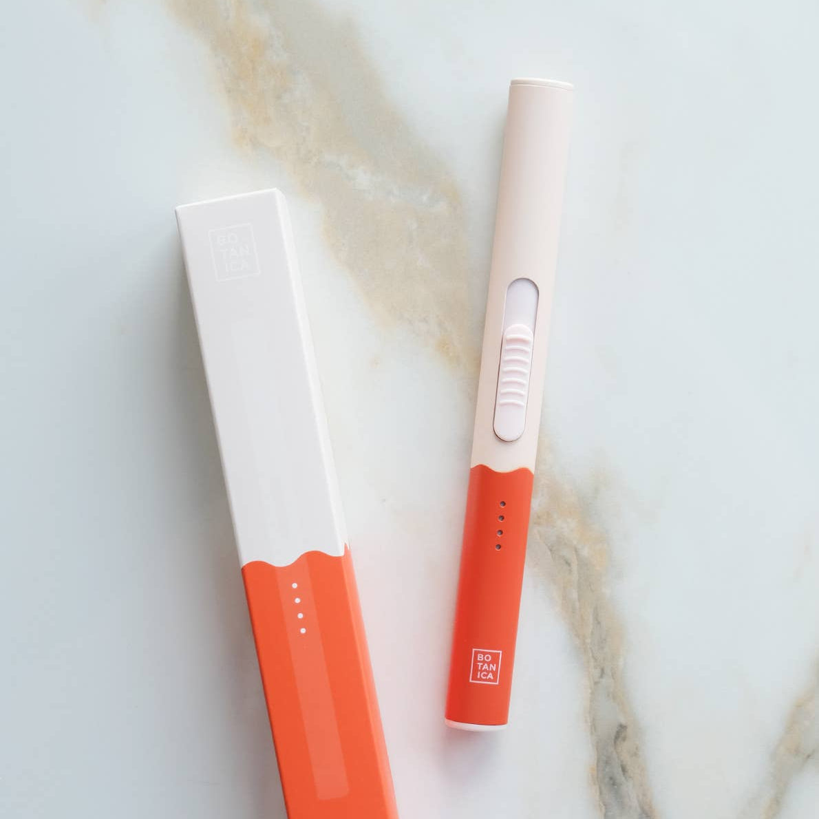 A flameless rechargeable lighter in an orange and white color scheme, displayed next to its packaging on a marble surface.