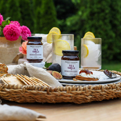 Provisions Vanilla products on a table with figs, crackers, and flowers.