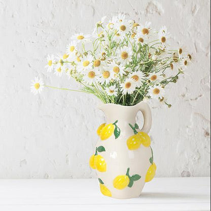Vase with lemon design filled with flowers on a white background