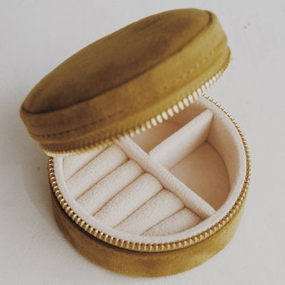 Round velvet jewelry box with a ring inside on a white background