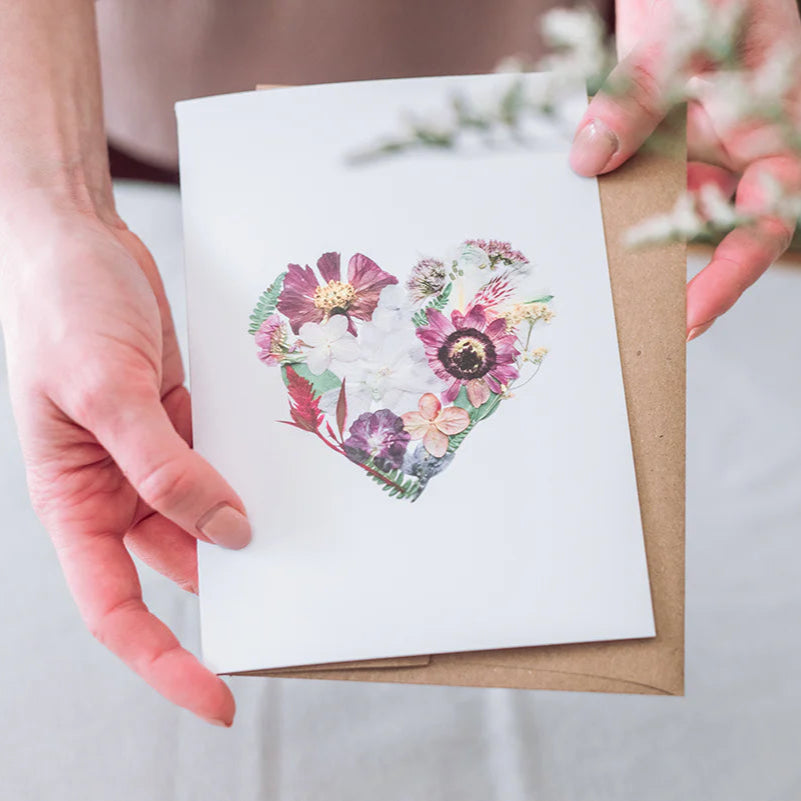 Person holding a card with a floral heart design