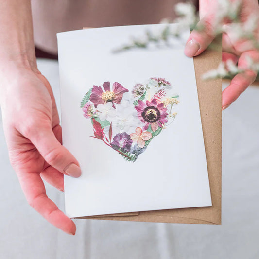 Person holding a card with a floral heart design