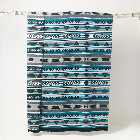 Patterned blanket with blue, gray, and white colors on a white background